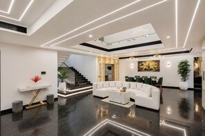 Un interior moderno con un sofá blanco, un comedor y una escalera.