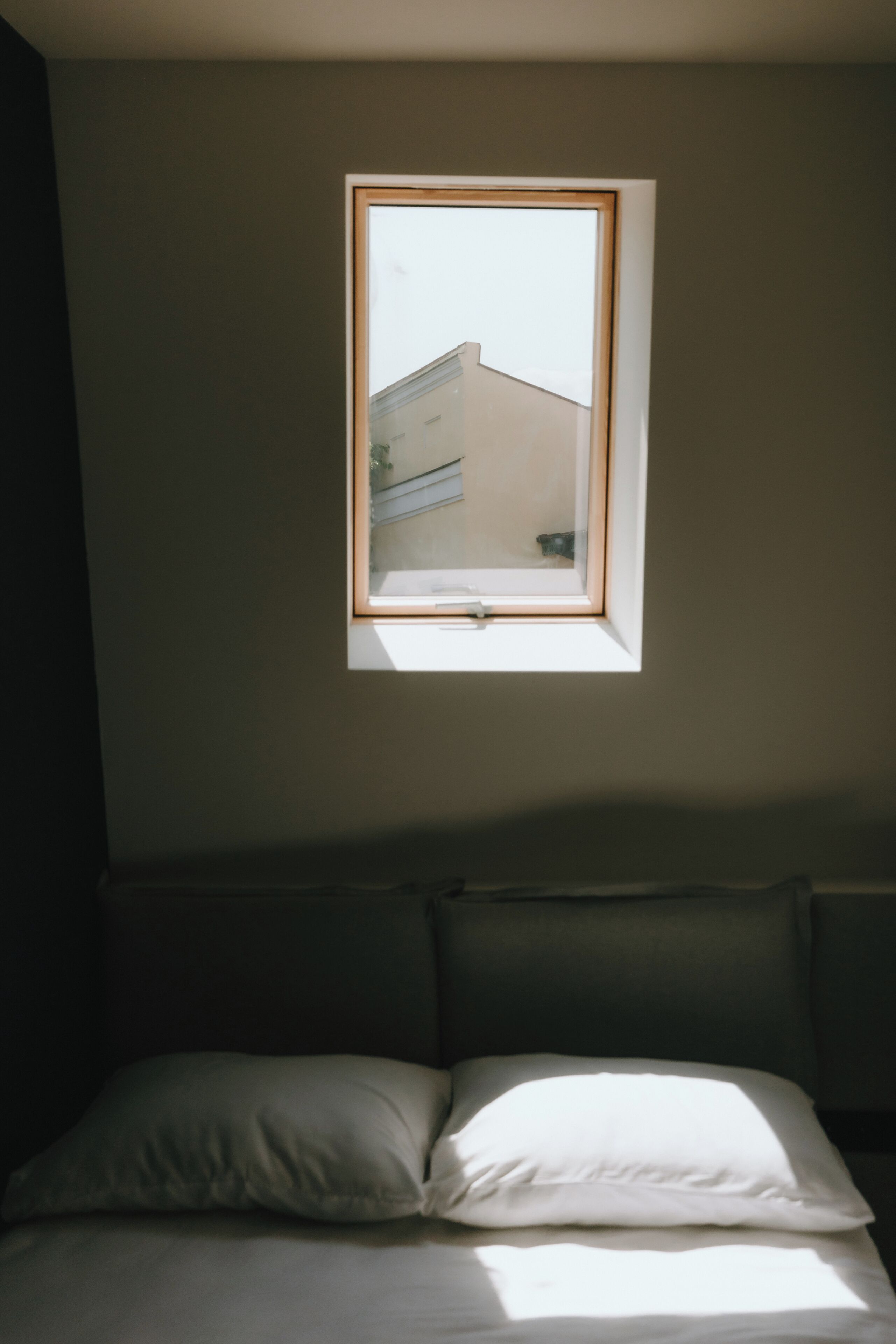 Una habitación con una cama, un ventanal y vistas a un edificio.