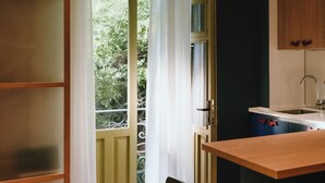 A modern kitchen with a wooden countertop, a sink, and a window with curtains.