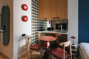 A compact kitchen with a central island, wooden cabinets, and a patterned wall.