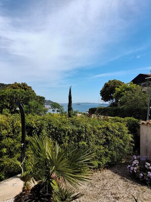 A garden with a variety of plants, a pathway, and a view of the sea. - Family home on the port of Le Niel (Hyères)