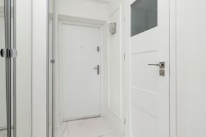A white door with a handle, a doorbell, and a small window above it.