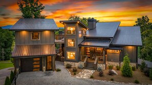 A multi-story house with a stone foundation, multiple entry points, and a driveway leading to a gated entrance. - 6 Acre Summit: High-End Escape • Pool • HotTub • FirePit • Creek Access • Games (Epworth)