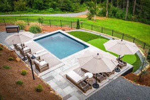 A swimming pool with a sun lounger and umbrella seating area. - 6 Acre Summit: High-End Escape • Pool • HotTub • FirePit • Creek Access • Games (Epworth)