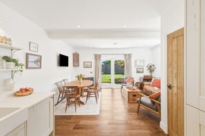 A spacious room with a dining area, a sofa, and a view of a garden through a sliding door. - 20 Applegrove - Home from Home in Monifieth (Monifieth)