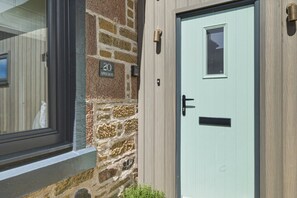 A stone facade with a door, a window, and a sign indicating the address. - 20 Applegrove - Home from Home in Monifieth (Monifieth)