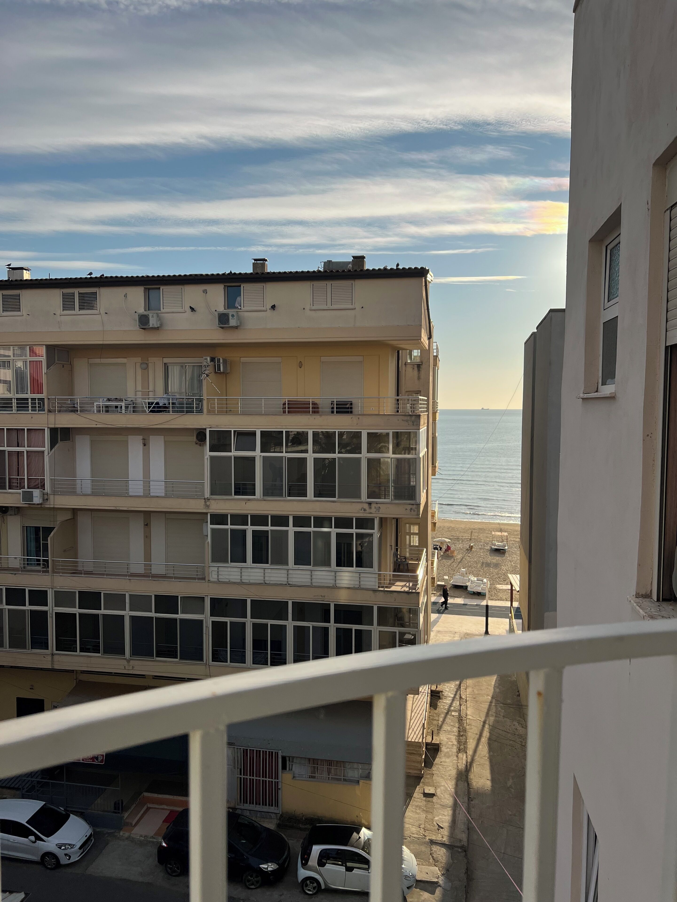 A multi-story building with balconies overlooking a beach.