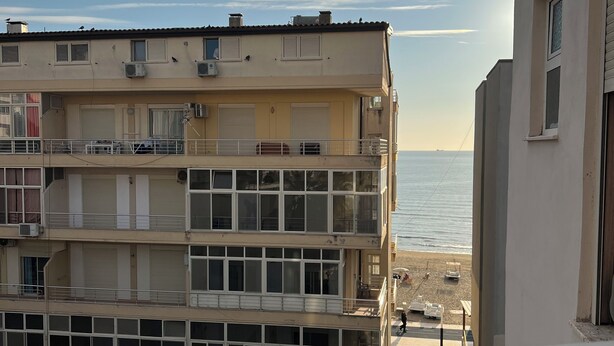 Ein mehrstöckiges Gebäude mit Balkonen mit Blick auf einen Strand.