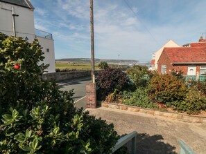 A residential street with houses, a clear sky, and a view of the sea. - Beachcrest (Whitby)
