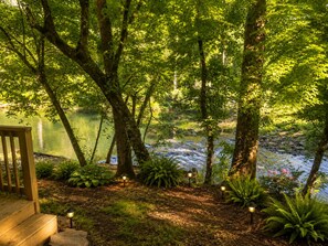 Ein friedlicher Außenbereich mit Holzterrasse, Teich und kleinem Wasserfall.