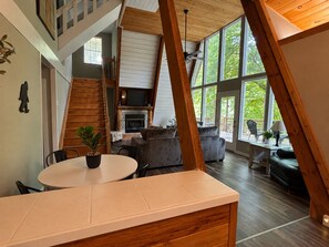 Ein Loft-Zimmer mit Kamin, Essbereich und großem Fenster.