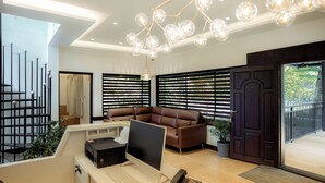 A modern interior with a desk, computer, and leather sofa. - Aroma Hills Resort (Udumbanchola)
