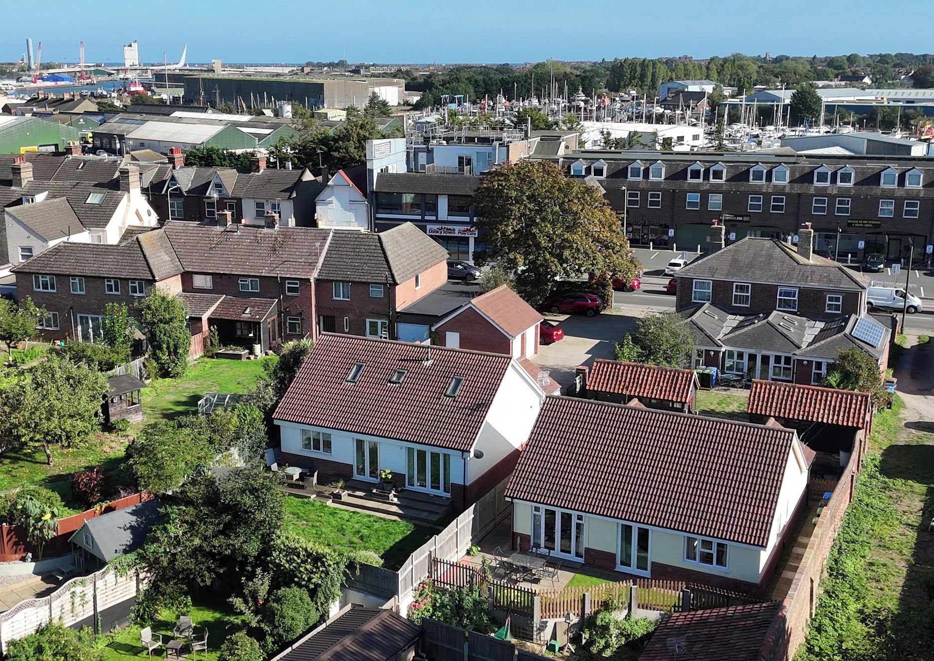 A residential area with houses, a marina, and a clear sky.