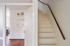 A staircase with a wooden handrail and a white wall. - Family House Fahrenheit - dunes, garden and room for six (Zandvoort)