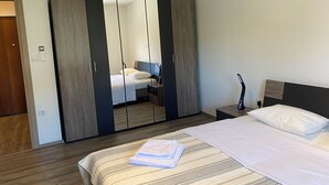Ein Hotelzimmer mit Bett, Schrank, Nachttisch und Beistelltisch.
