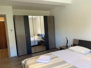 Ein Hotelzimmer mit Bett, Schrank, Nachttisch und Beistelltisch.
