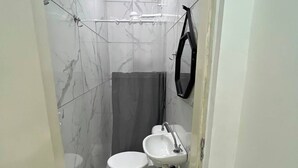 Een badkamer met toilet, wastafel en douche.