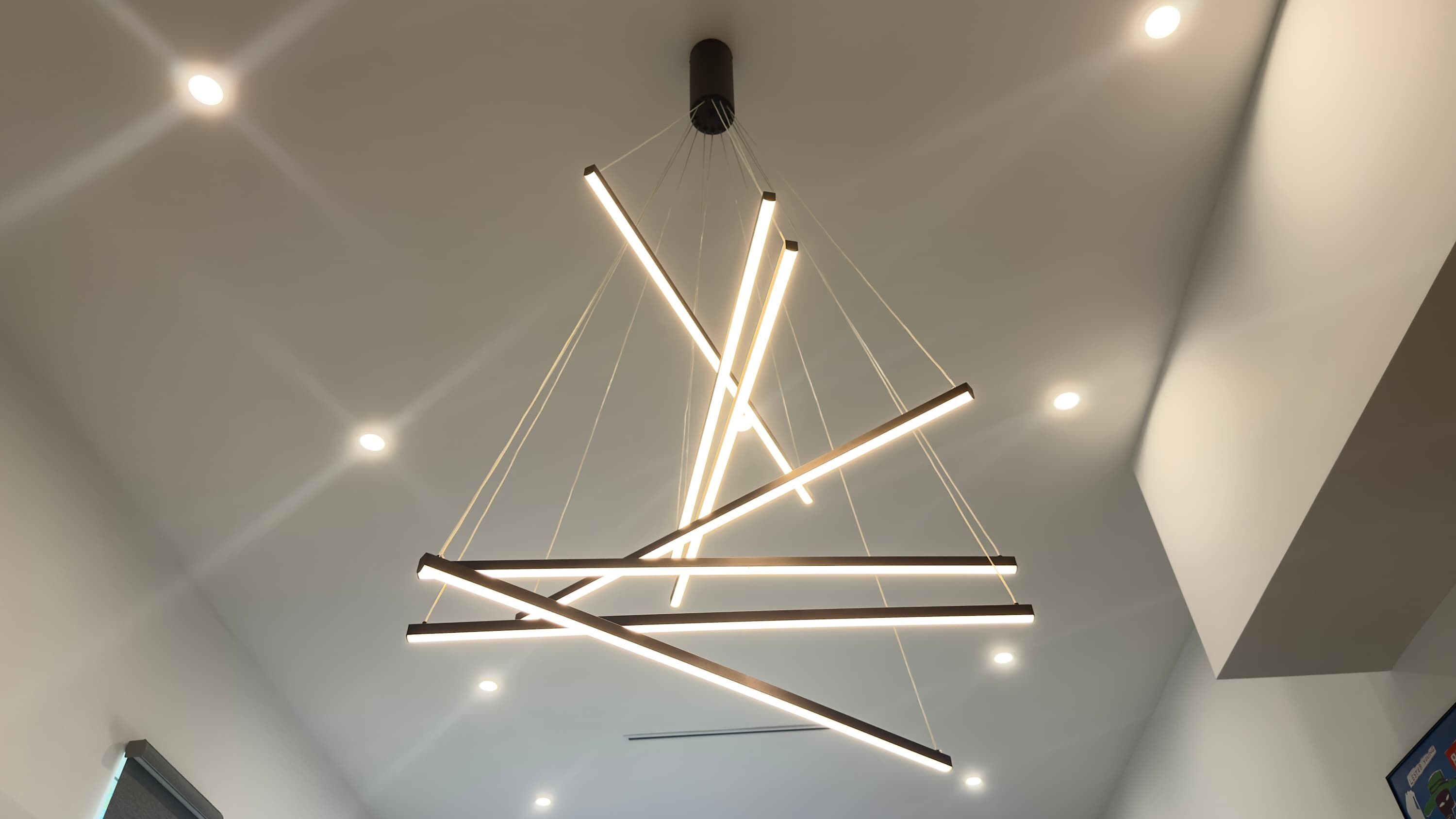 A modern ceiling with intersecting light fixtures.