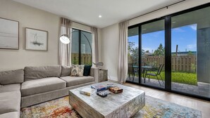Una sala moderna con un sofá, una mesa de centro y vistas al exterior.