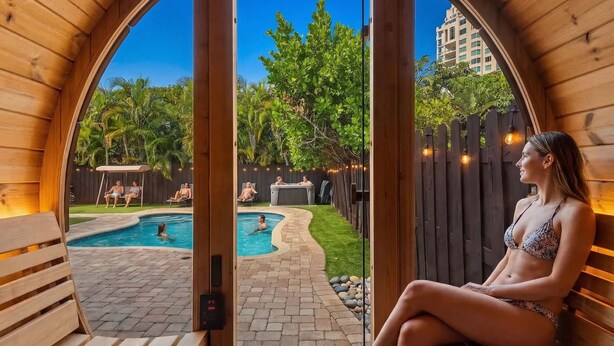 Une cabane en bois avec une piscine, un espace extérieur aménagé et une vue sur un quartier résidentiel.