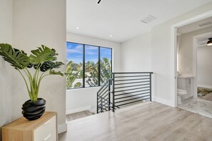 Ein modernes Interieur mit einer Treppe, einem großen Fenster mit Aussicht und einem Blumentopf.
