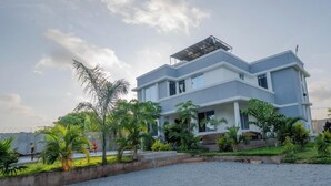 Uma casa de dois andares com teto plano, varanda e varanda frontal.