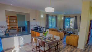 Uma sala de estar moderna com uma mesa de jantar, sofá e cozinha.