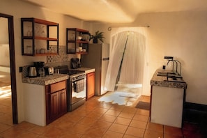 A kitchen with a stove, sink, and cabinets.