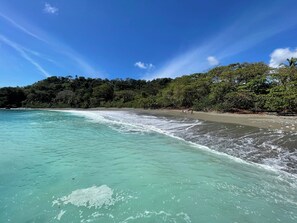 A beach with clear turquoise water and a sandy shore.