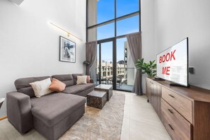 Ein modernes Wohnzimmer mit einer Couch, einem Couchtisch und einem Fernseher.