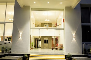 Ein Hotel mit Eingangsbereich, einer Treppe, einer Rezeption und einer Kristallleuchter.