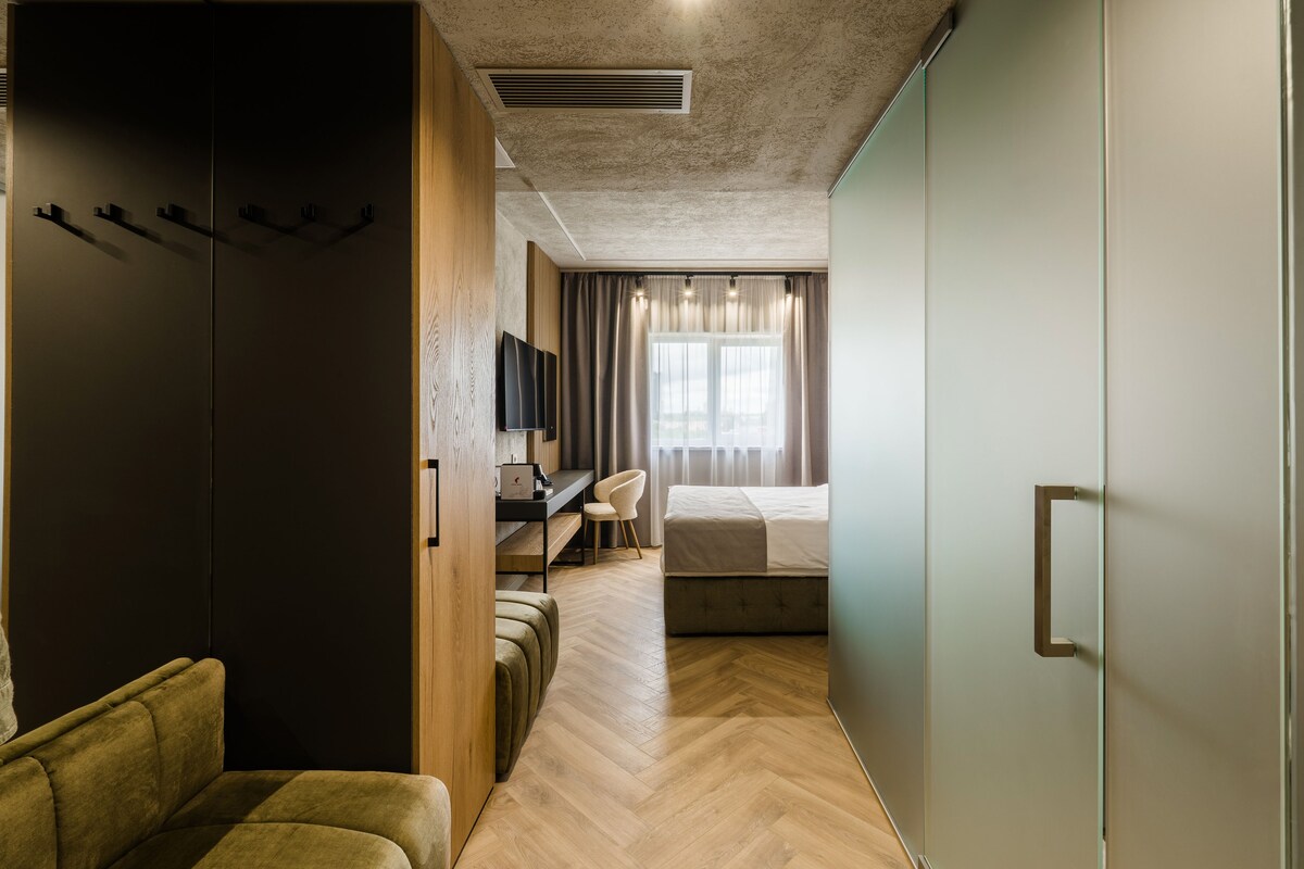 Una habitación de hotel con cama, escritorio, silla, armario y televisor.