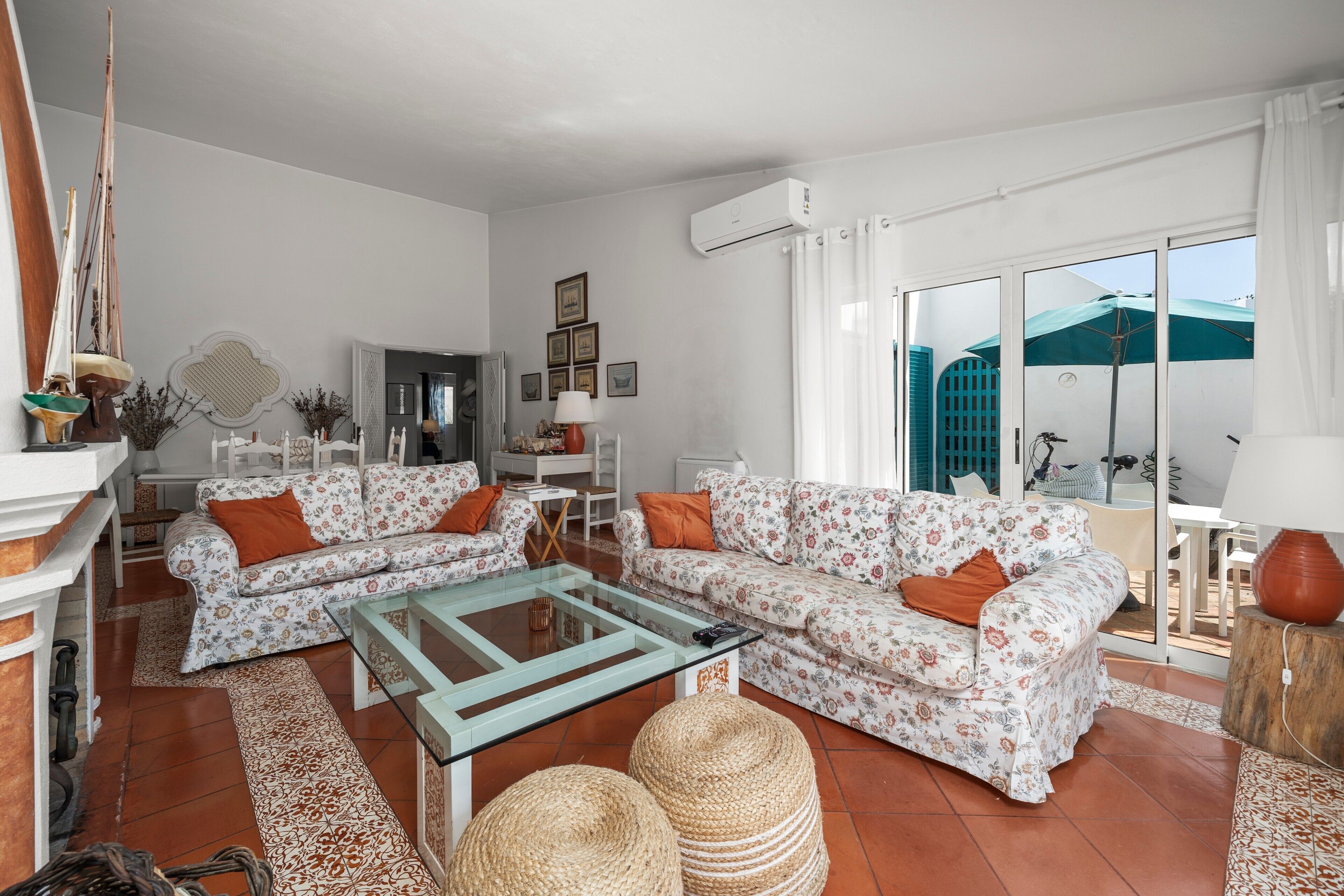 A living room with a sofa set, a glass coffee table, and a fireplace.