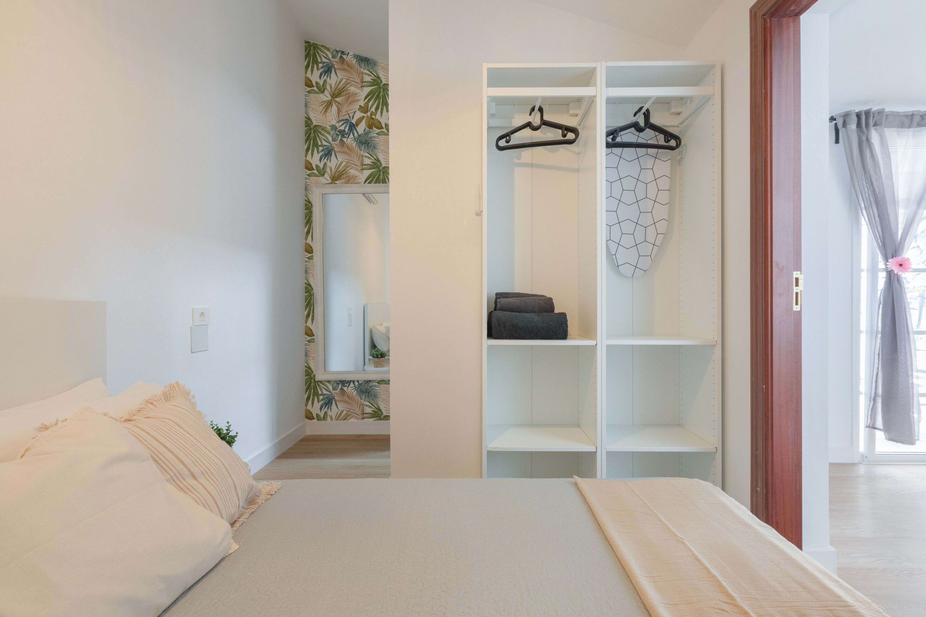 Ein Schlafzimmer mit einem Bett, einem Kleiderschrank und einem durchgegangenen Tür erkennbaren Badezimmer.