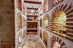 A narrow passageway with brick walls and stone flooring, leading to a staircase. - Hacienda del Cazador: Luxury Villa in La Alquería (Mijas Pueblo)
