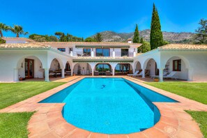 A pool with a clear blue water, surrounded by a white building with arches and a tiled roof. - Hacienda del Cazador: Luxury Villa in La Alquería (Mijas Pueblo)