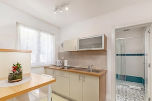 Een moderne keuken met een magnetron, spoelbak en kasten.