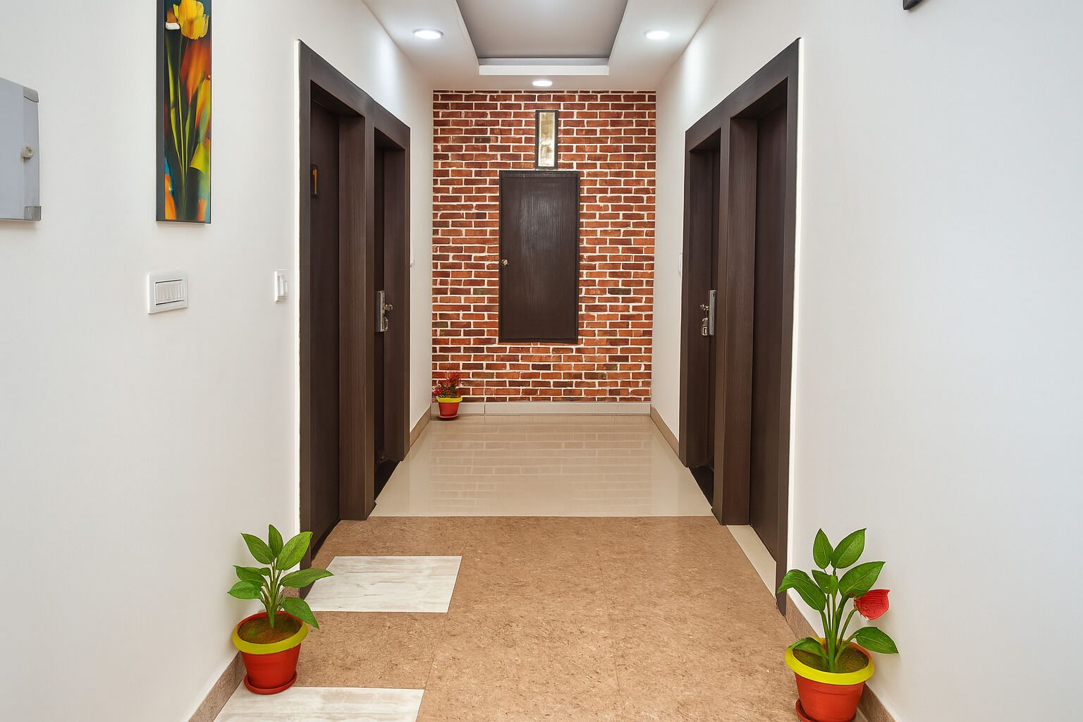 Um corredor com parede de tijolos, portas de madeira e plantas em vasos.