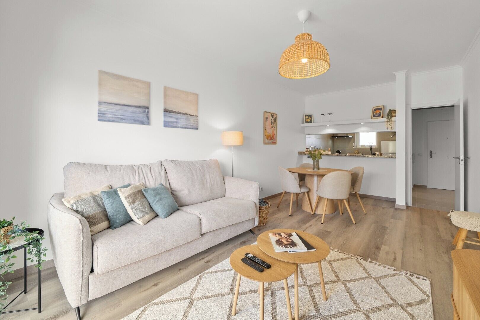 Uma sala de estar moderna com sofá, mesa de centro e área de jantar.