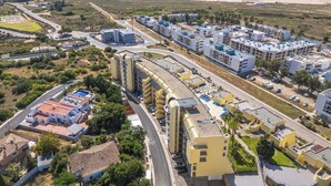Vista aerea di una zona costiera con un grande complesso di edifici, strade e una spiaggia.