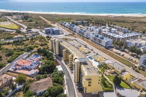 Eine Luftaufnahme einer Küstenregion mit einem großen Gebäudekomplex, Straßen und einem Strand.