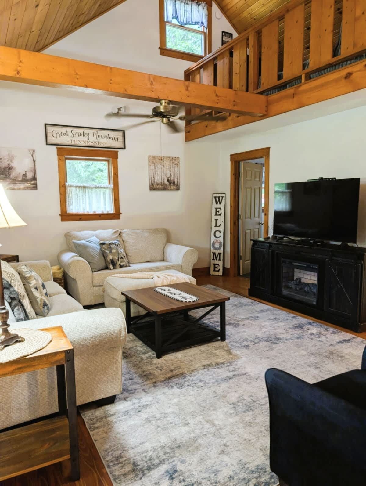 A cozy living room with a sofa, a coffee table, a fireplace, and a television.