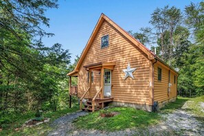 Eine Holzhütte mit Veranda, einer kleinen Terrasse und einer Sterndeko.