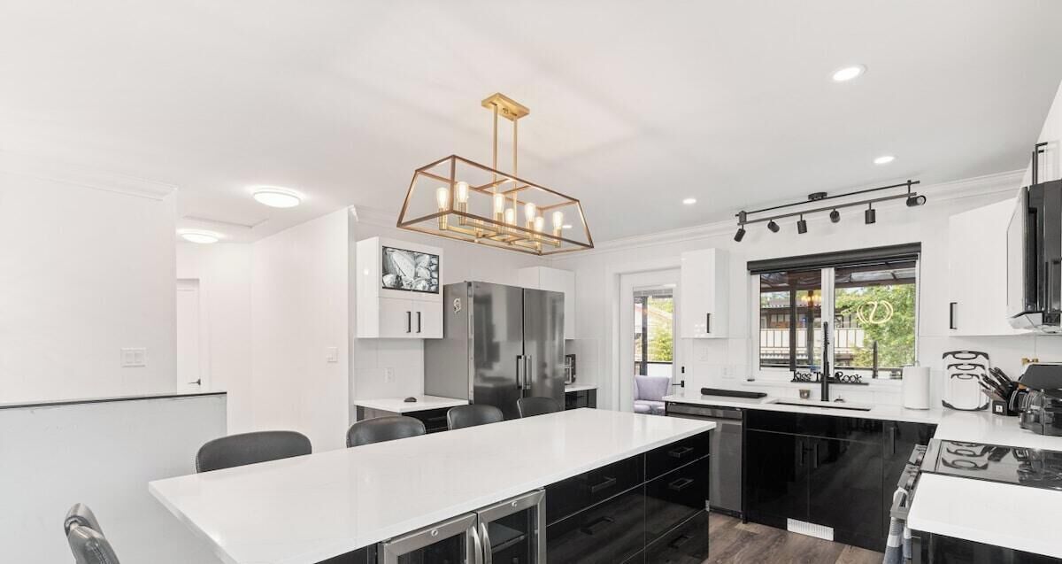 A modern kitchen with a central island, built-in appliances, and a pendant light.