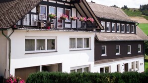 A two-story house with a balcony, large windows, and a sloped roof. - Wiebelhaus-Mester Farm Guesthouse – Schwalbennest Holiday Apartment (Lennestadt)