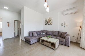 Una sala de estar moderna con un sofá gris, una mesa de centro y un cuadro en la pared.