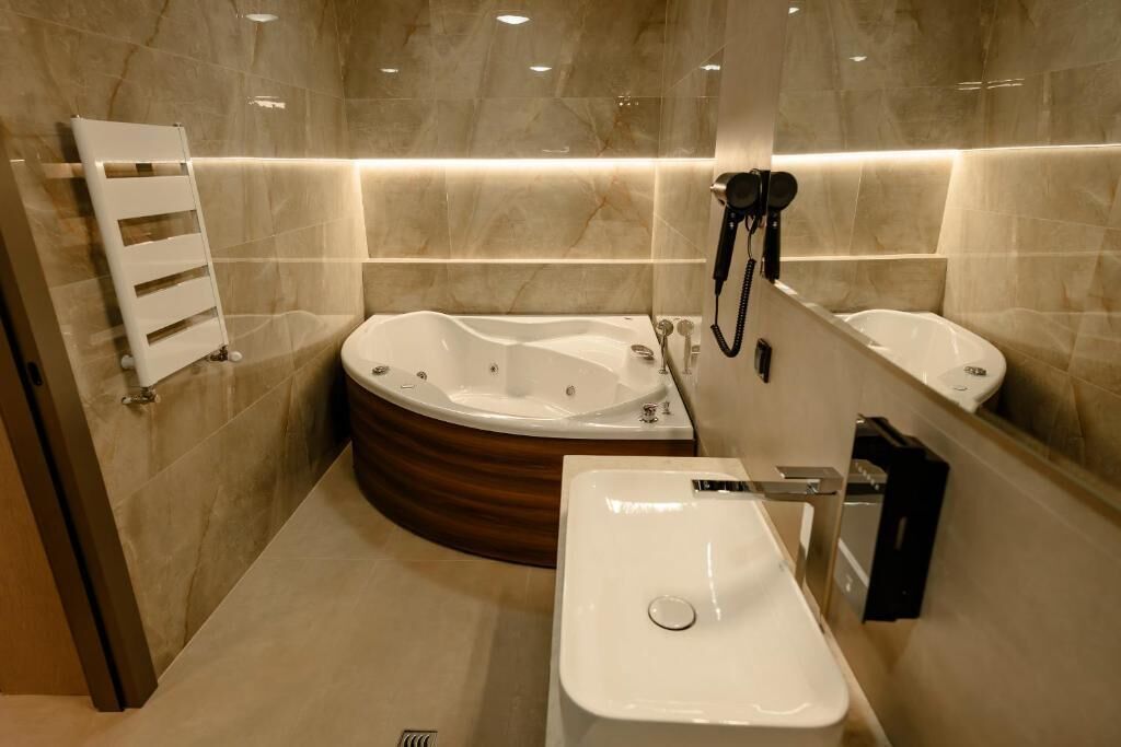 Une salle de bain moderne avec une baignoire sur pieds, un lavabo séparé et un porte-serviettes.