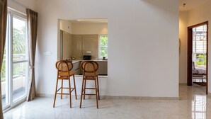 A modern kitchen with two wooden chairs, a large window, and a view of the outdoors.
