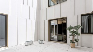 A modern interior with a tiled floor, a potted plant, and a sliding glass door leading to a dark interior. -  Genteel Home Solanilla  (Valladolid)