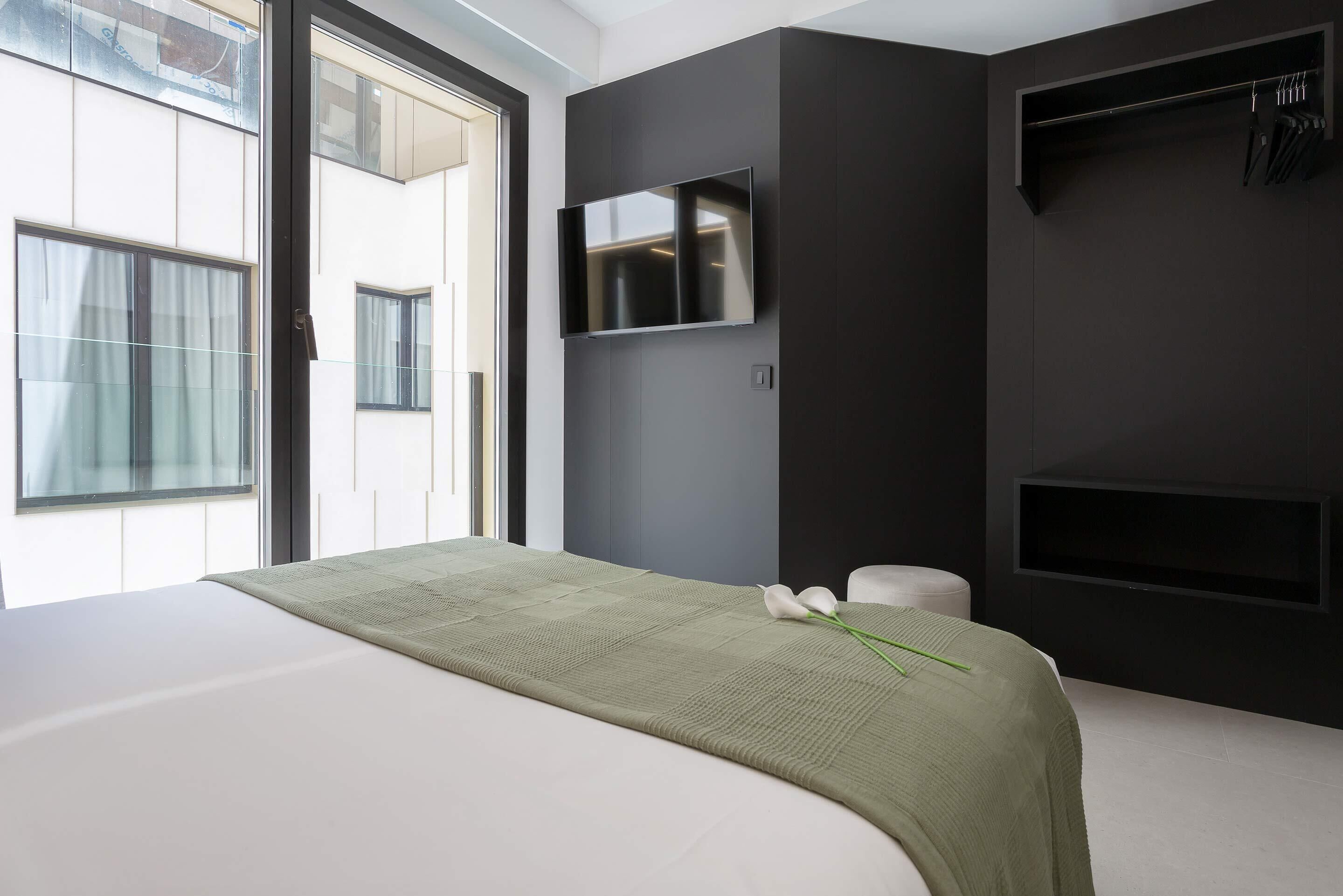 Une chambre à coucher moderne, équipée d’un lit, d’une télévision et d’une armoire.